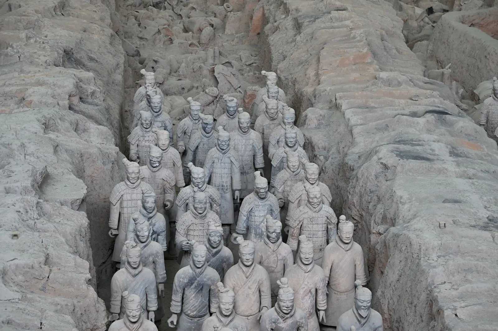 Rows of life-sized terracotta warriors standing in the excavated earthen corridors of Pit 1 at the mausoleum of Qin Shi Huang near Xi'an.