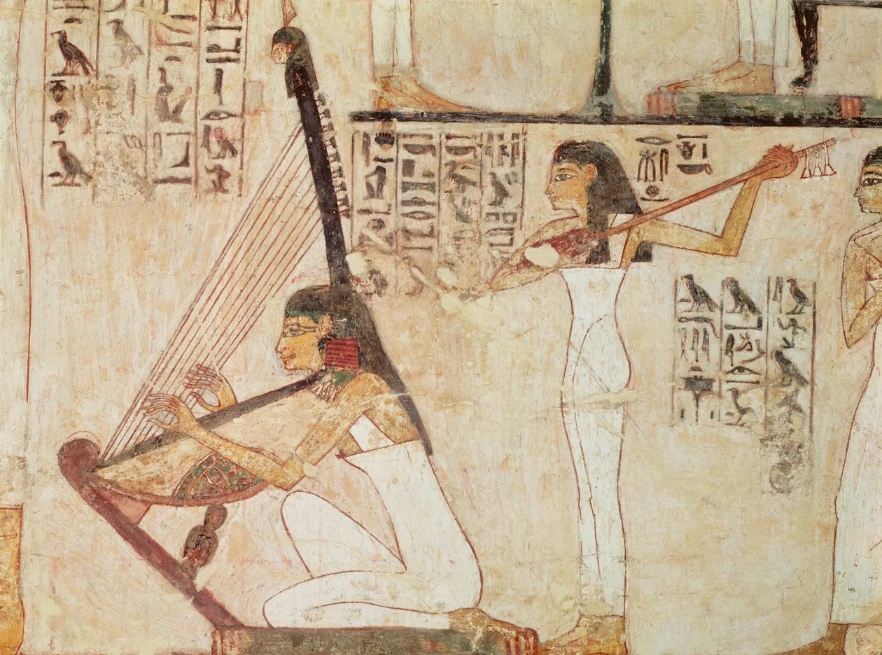 A seated harpist and a standing lutenist in a painted banquet scene from the Tomb of Rekhmire, framed by columns of hieroglyphs.
