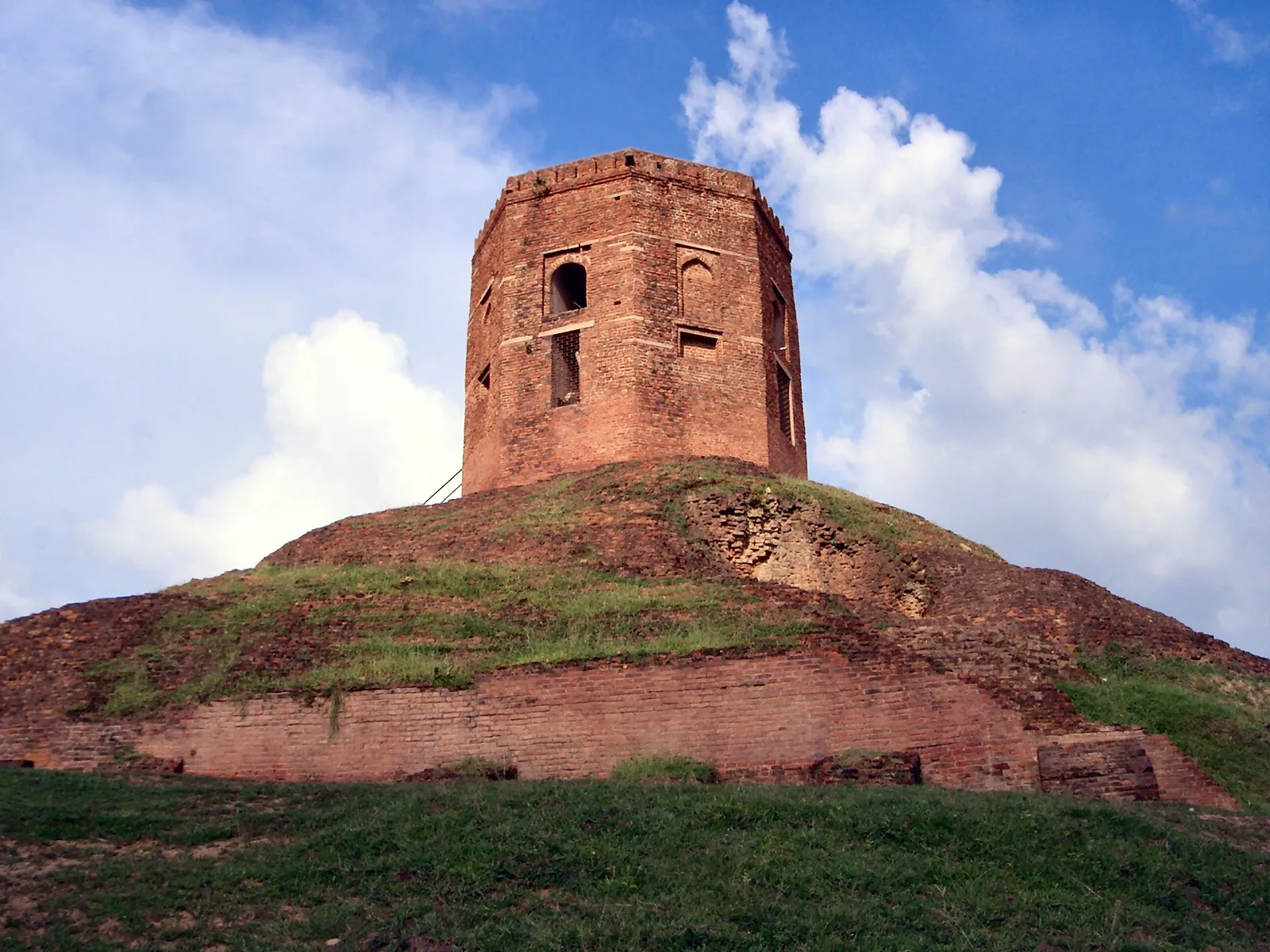 The grassy brick mound of the Chaukhandi Stupa at Sarnath, topped by a Mughal octagonal brick tower.